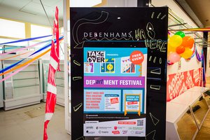An old debenhams sign with department festival poster